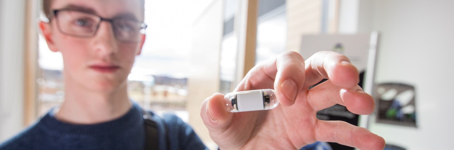 A GI Digital team member holding a capsule camera